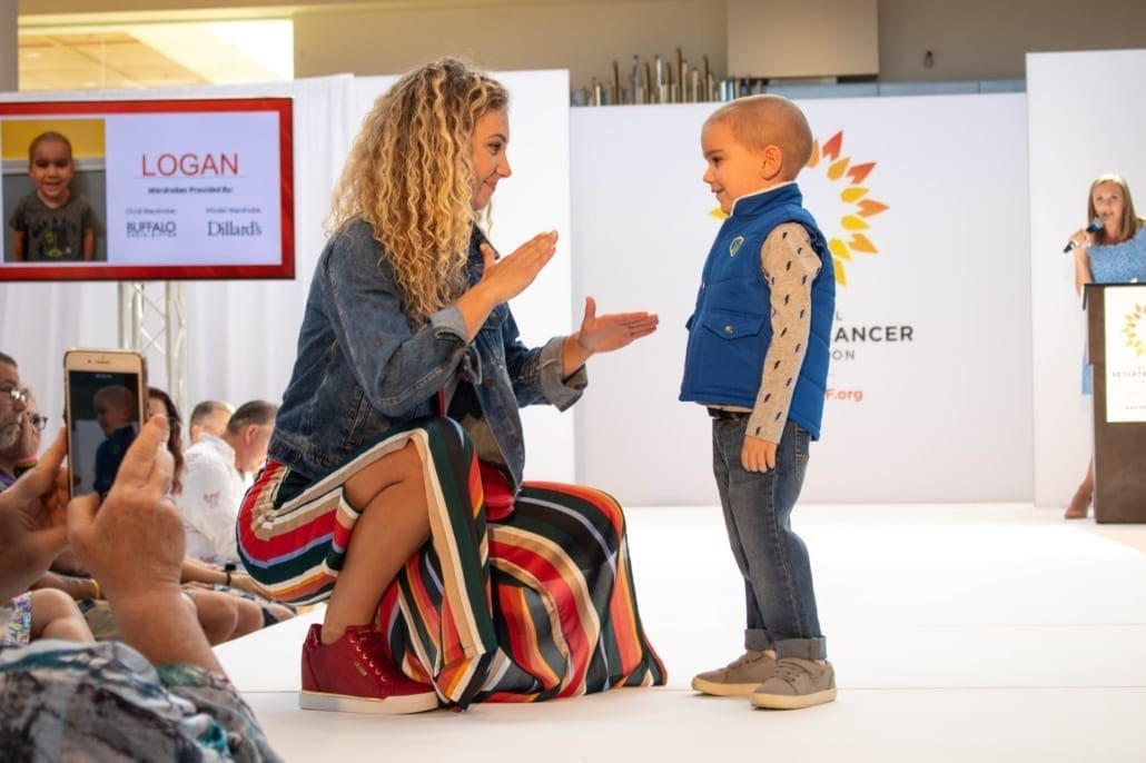 Logan Walking with a model at Fashion Funds the Cure