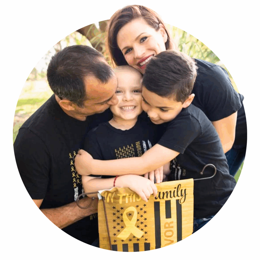 Family embracing a smiling child with a "Survivor" flag, possibly related to pediatric cancer research foundation 5k.